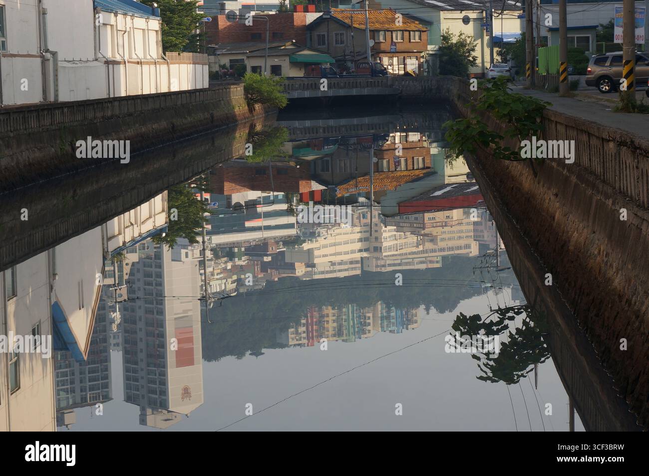 Reflexion über die ruhige Wasseroberfläche des Kanals. Am frühen Morgen, städtische Landschaft. Busan, Südkorea. Stockfoto