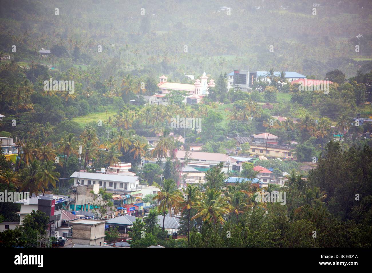 Aus der Vogelperspektive auf ein wunderschönes Walddorf in der Nähe der Berge in Kanthalloor, Munnar, Kerala, Indien. Die malerische Landschaft bietet üppiges Grün und Nebel Stockfoto