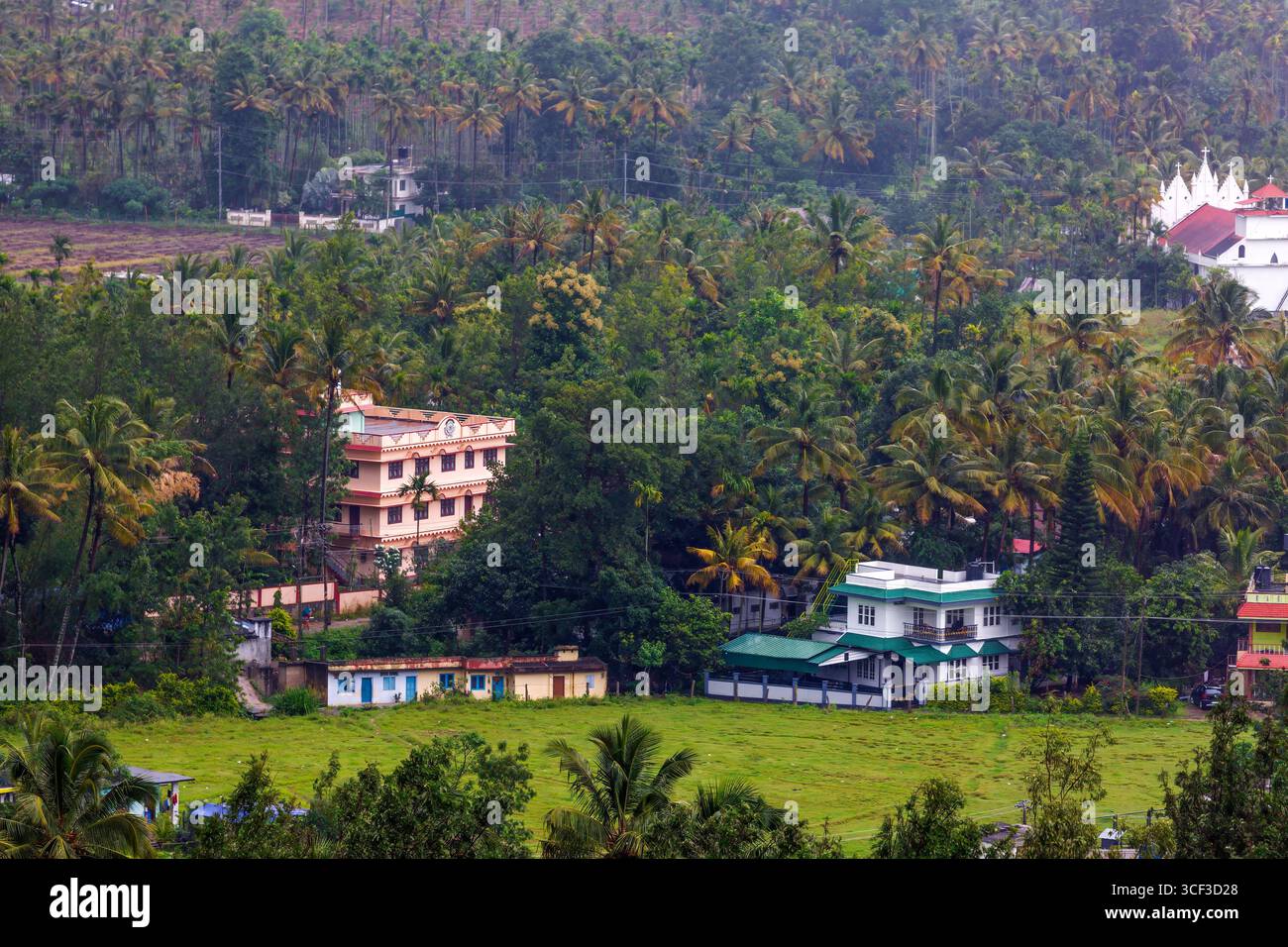 Aus der Vogelperspektive auf ein wunderschönes Walddorf in der Nähe der Berge in Kanthalloor, Munnar, Kerala, Indien. Die malerische Landschaft bietet üppiges Grün und Nebel Stockfoto