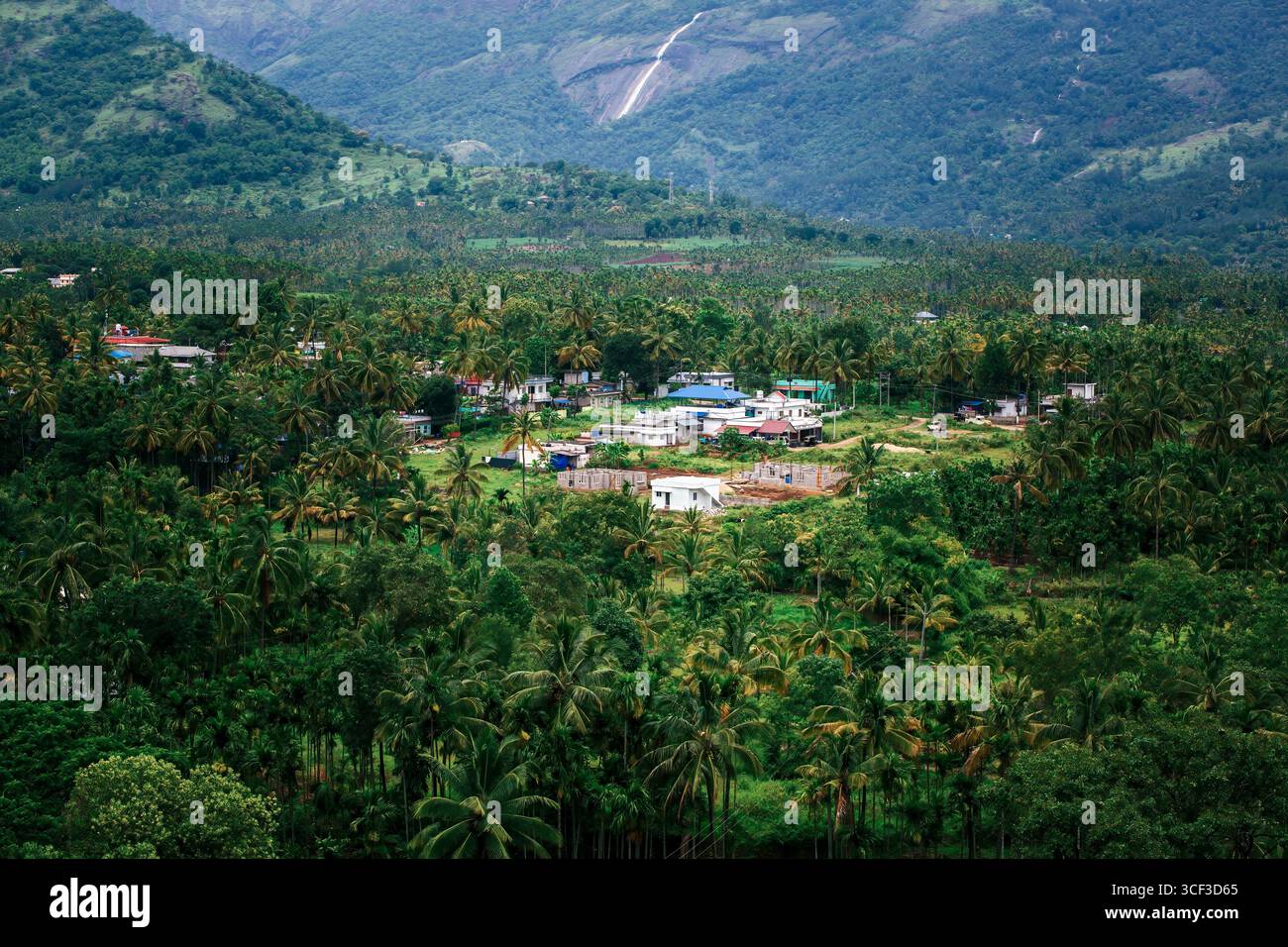 Aus der Vogelperspektive auf ein wunderschönes Walddorf in der Nähe der Berge in Kanthalloor, Munnar, Kerala, Indien. Die malerische Landschaft bietet üppiges Grün und Nebel Stockfoto