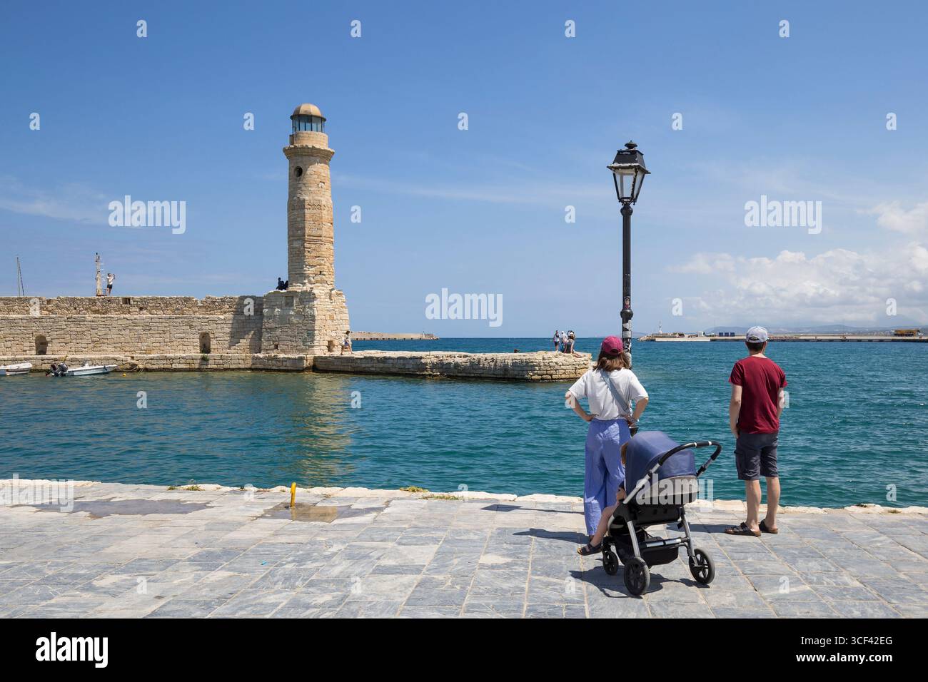 Junge Familie mit Blick auf den Leuchtturm am venezianischen Hafen, Rethymnon, Kreta, Griechenland, Europa Stockfoto