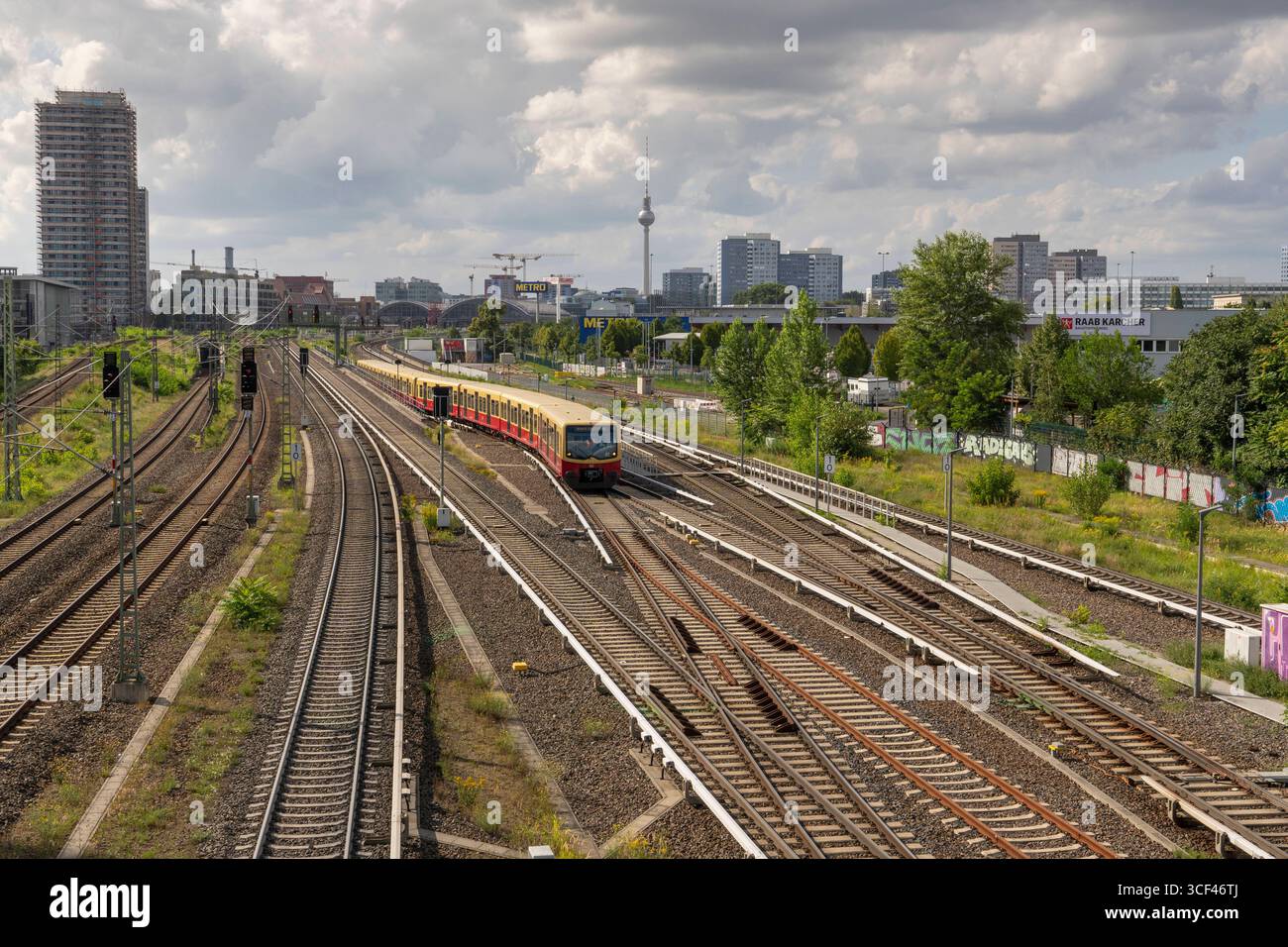 Zwei S-Bahnen vor der Einfahrt in den S-Bahnhof Warschauer Straße in Berlin-Friedrichshain. In der Bildmitte im Hintergrund der Ostbahnhof und der Fernsehturm am Alexanderplatz. *** Zwei S-Bahn-Züge vor der Einfahrt in den S-Bahnhof Warschauer Straße in Berlin Friedrichshain in der Bildmitte im Hintergrund der Ostbahnhof und der Fernsehturm am Alexanderplatz Stockfoto