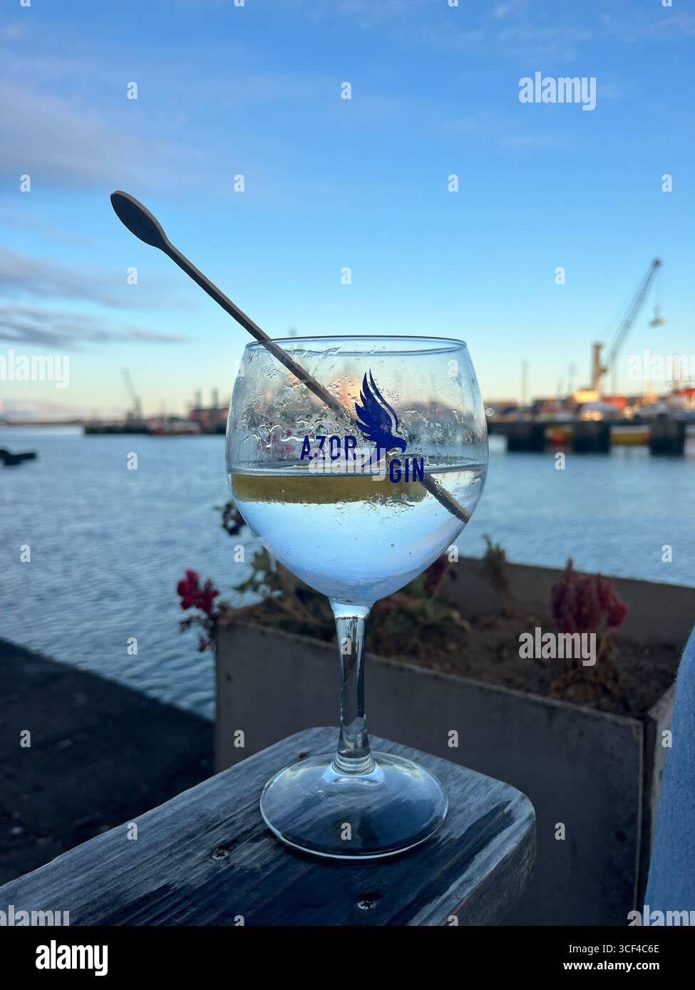 Erfrischender Cocktail mit Zitrone bei Sonnenuntergang in der Nähe des Hafens in Ponta Delgada, São Miguel, Azoren, Portugal. - Smartphone-aufgenommenes Stockfoto