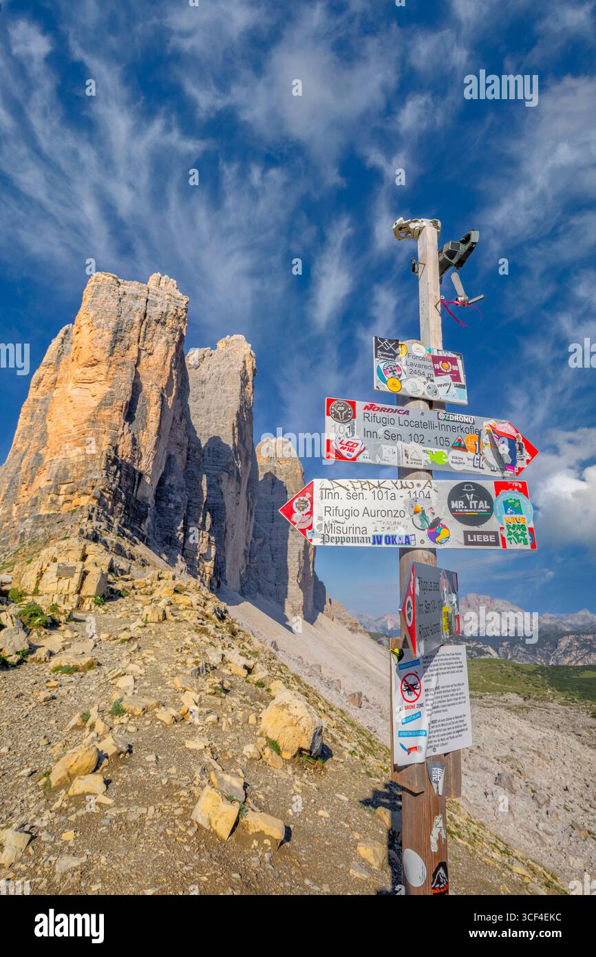 CAI-Schilder, die mit Aufklebern bedeckt sind, stehen in der Nähe des Wracks einer Drohne und dienen als Warnung vor der Flugverbotszone im Naturpark Tre Cime di Lavaredo. Naturpark Tre Cime di Lavaredo, Auronzo di Cadore, Belluno, Venetien, Italien Stockfoto