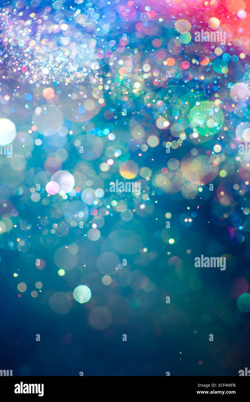 Der Regenbogen mit funkelndem Glitzer sorgt für ein mystisches und lebendiges Farbspektrum. Traumhafte oder magisch schimmernde Partikel, die in einem Bokeh aus Lichtern leuchten. Et Stockfoto