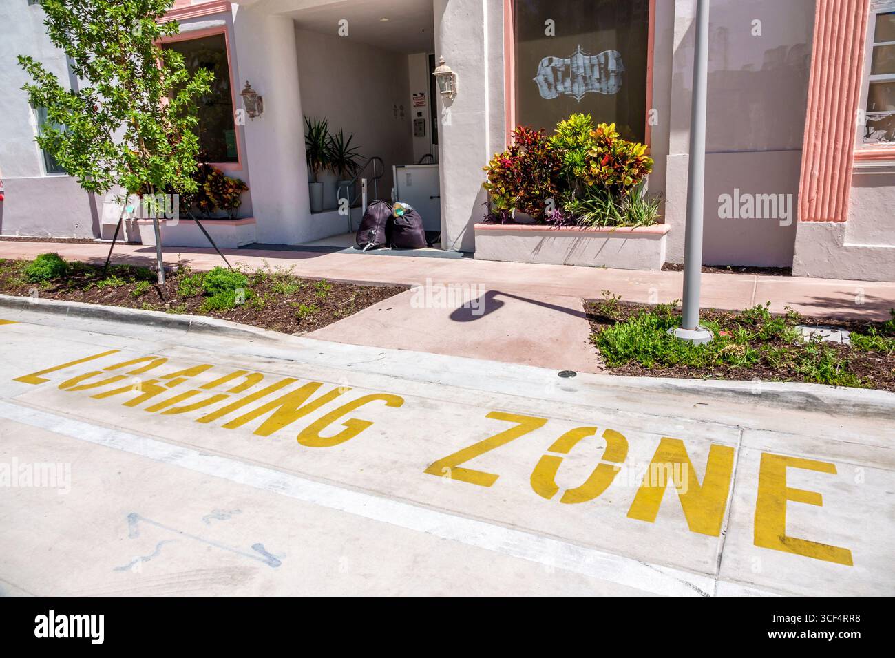 Miami Beach Florida, North Beach, 73rd Street, Olsen Hotel Ferienwohnung, Ladezone gelbe Straßenmarkierung, Gehsteig Pflanzen Landschaftsgestaltung, Müllsäcke links Stockfoto