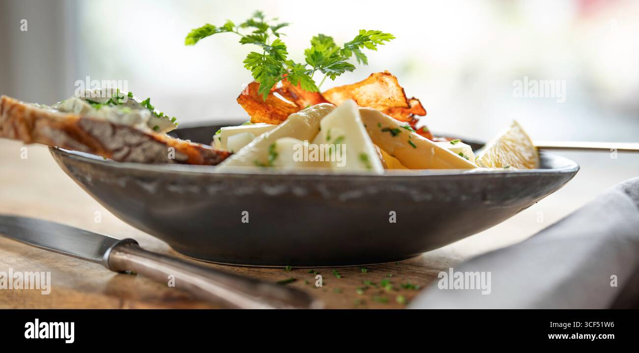 Weißer Spargel mit frischen Zutaten in einer dunklen Keramikschale auf rustikalem Holz. Hintergrund für halthy Nutrion und Fitness. Stockfoto