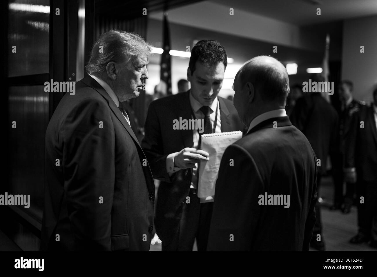 Anchorage, Vereinigte Staaten von Amerika. August 2025. US-Präsident Donald Trump, links, spricht mit dem russischen Präsidenten Wladimir Putin, rechts, durch einen nicht identifizierten Dolmetscher, Center, nach einer gemeinsamen Pressemitteilung auf der Joint Base Elmendorf Richardson, 15. August, in Anchorage, Alaska. Trump lädt Putin zu Gesprächen ein, um den russischen Krieg in der Ukraine zu beenden. Quelle: Daniel Torok/White House Photo/Alamy Live News Stockfoto