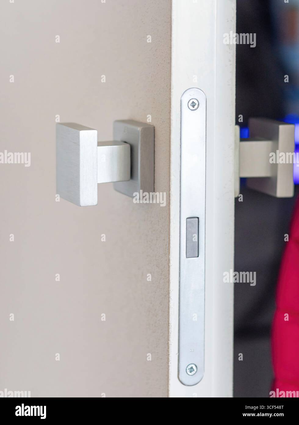 Nahaufnahme eines modernen quadratischen Türgriffs und Verriegelungsmechanismus, der Sicherheitsfunktionen und Zugangskontrolle in einer stilvollen, modernen Inneneinrichtung hervorhebt Stockfoto