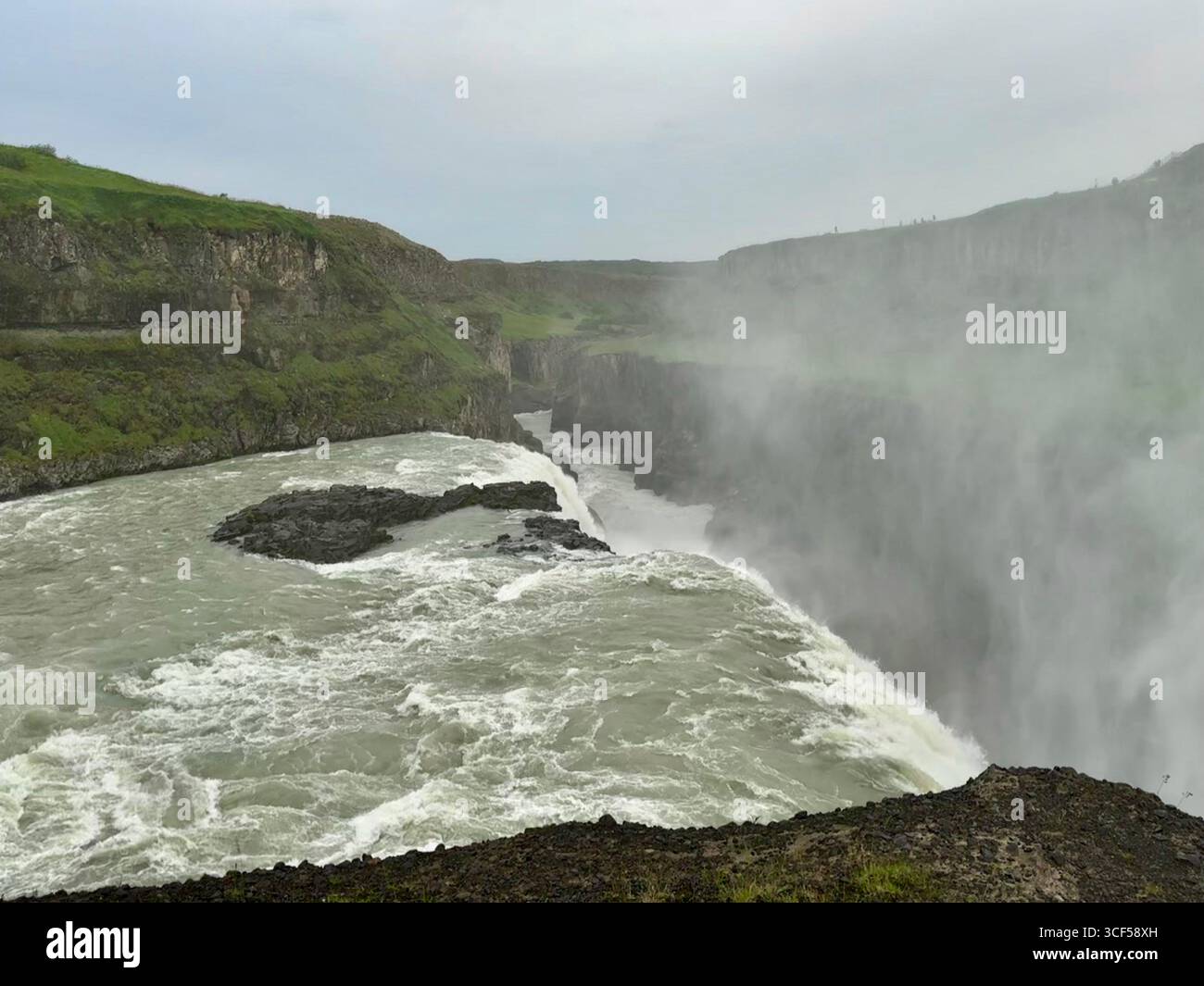 Aufsteigender Nebel aus dem Wasser, der in den Canyon bei Gulfoss überströmt. - Smartphone-aufgenommenes Stockfoto
