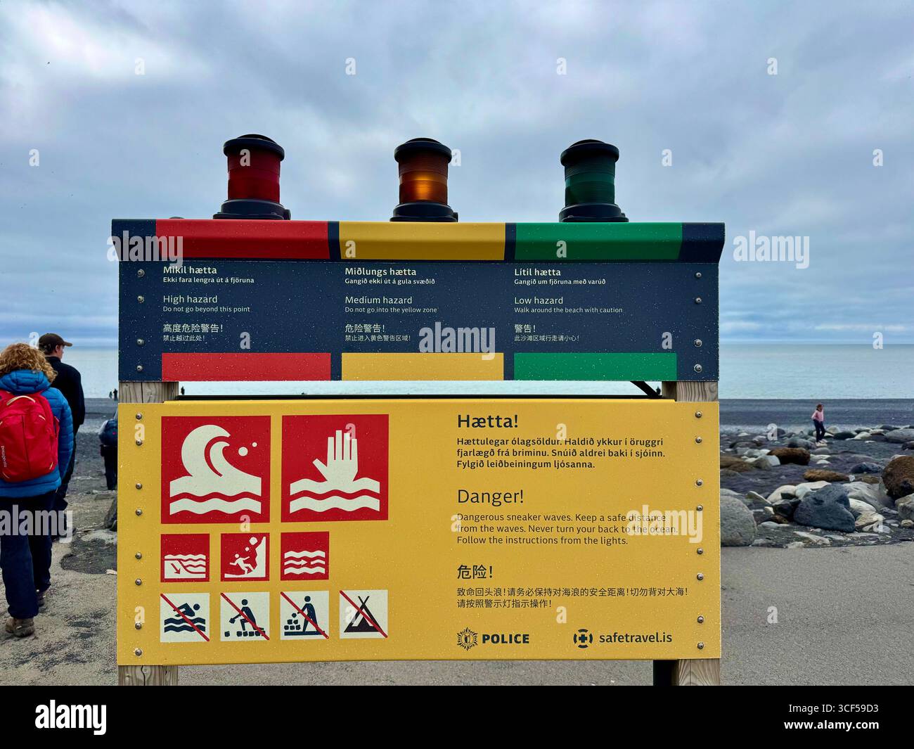 Drei Lichter auf dem Warnschild am berühmten schwarzen Sandstrand von Reynisjfara, bekannt für gefährliche Sneaker-Wellen, zeigen Sicherheitszonen an jedem Tag an. - Smartphone-aufgenommenes Stockfoto