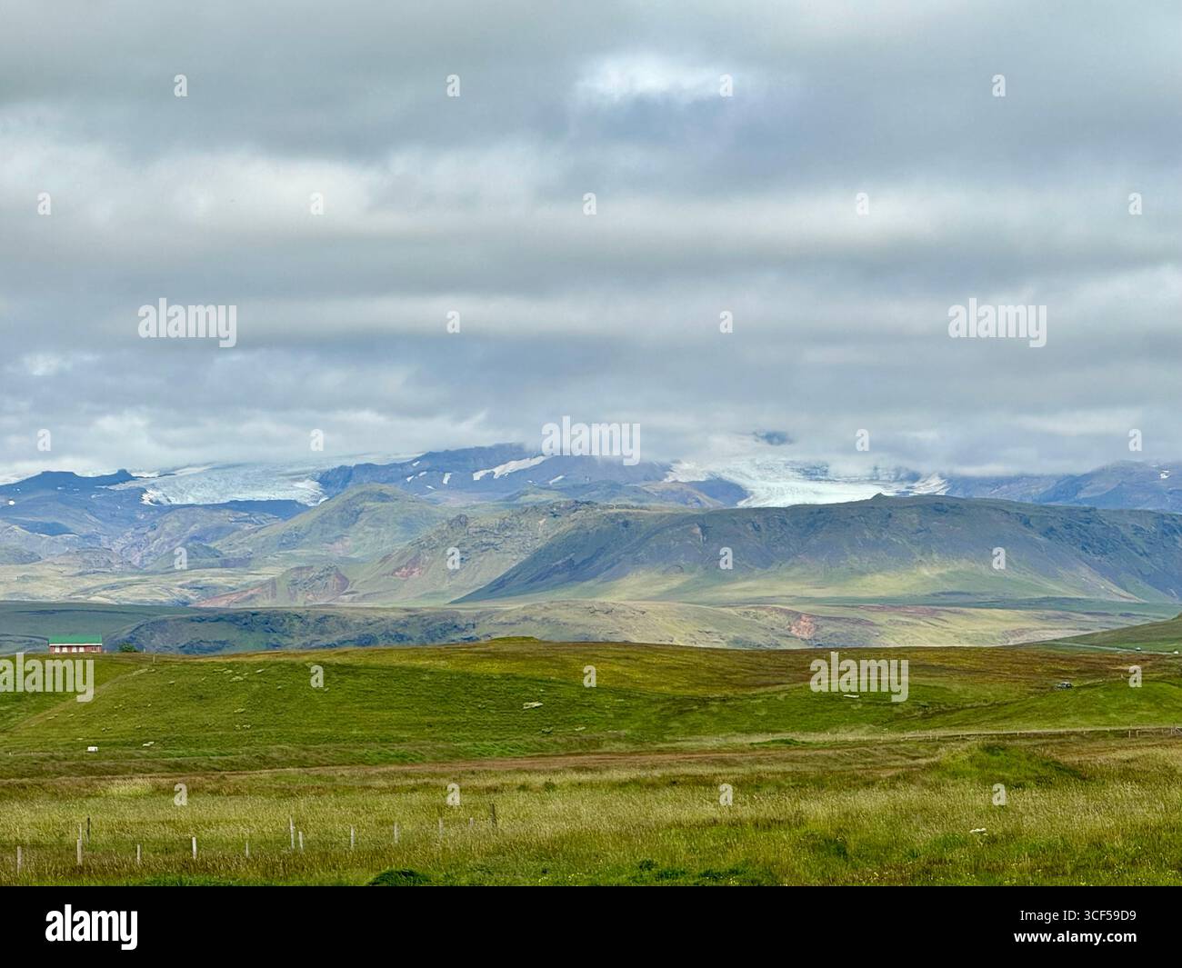 Myrdalsjokull-Gletscher umgeben von üppigem Grün im Vordergrund, von Vik aus gesehen an einem Sommertag. - Smartphone-aufgenommenes Stockfoto