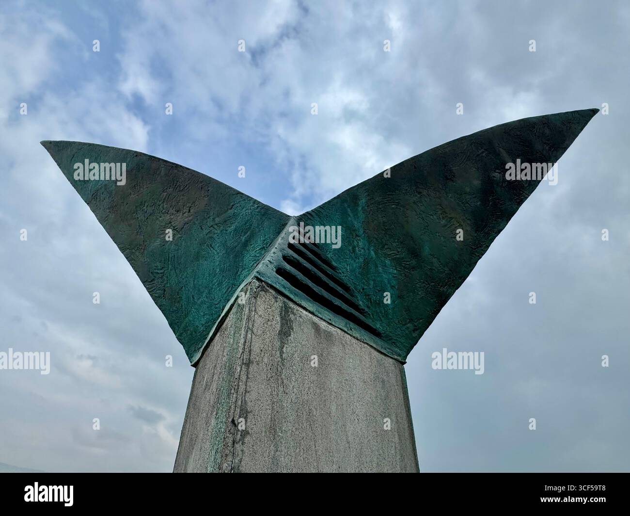 Der Fischschwanz der Farid-Skulptur in Akureyri, Island, vor einem bewölkten Sommerhimmel. - Smartphone-aufgenommenes Stockfoto