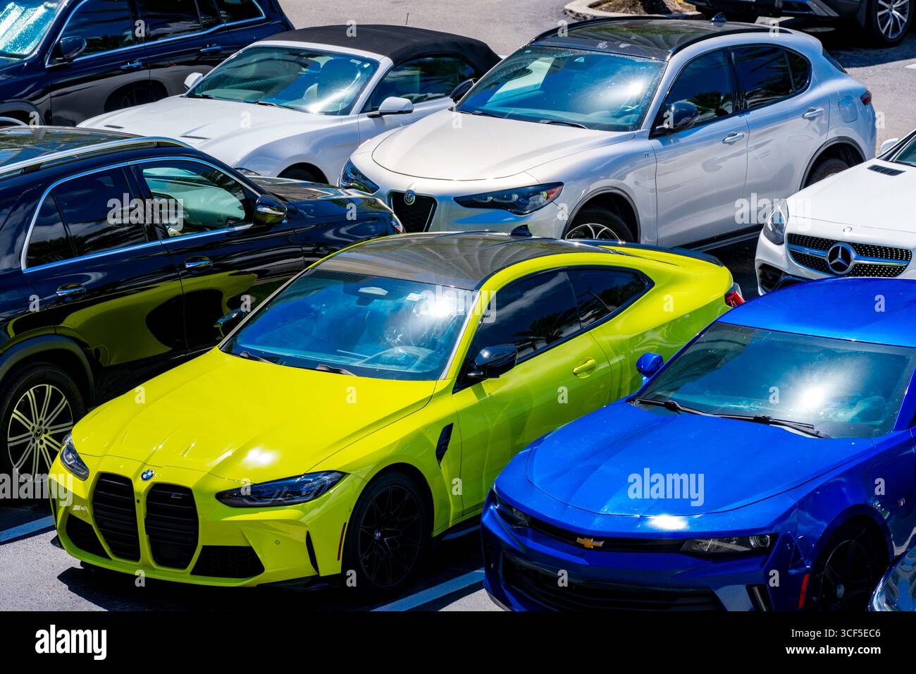 Sunny Isles Beach, FL, USA - 19. August 2025: Luftbild einer neongelben BMW Sportlimousine Stockfoto