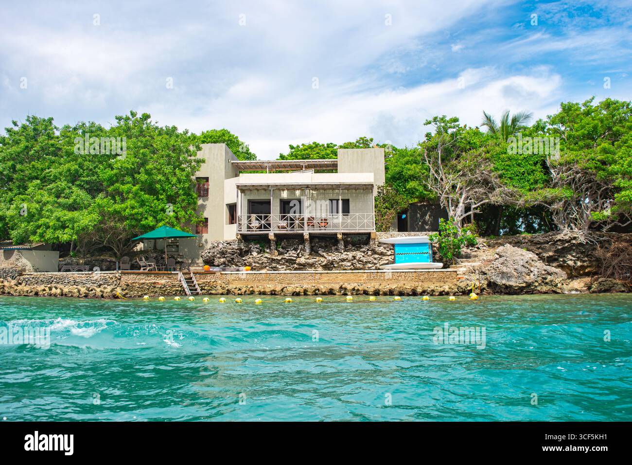 Atemberaubende Aussicht auf ein modernes Haus auf Rosario Island, umgeben von üppigem Grün und türkisfarbenem Wasser in Cartagena, Kolumbien. Stockfoto