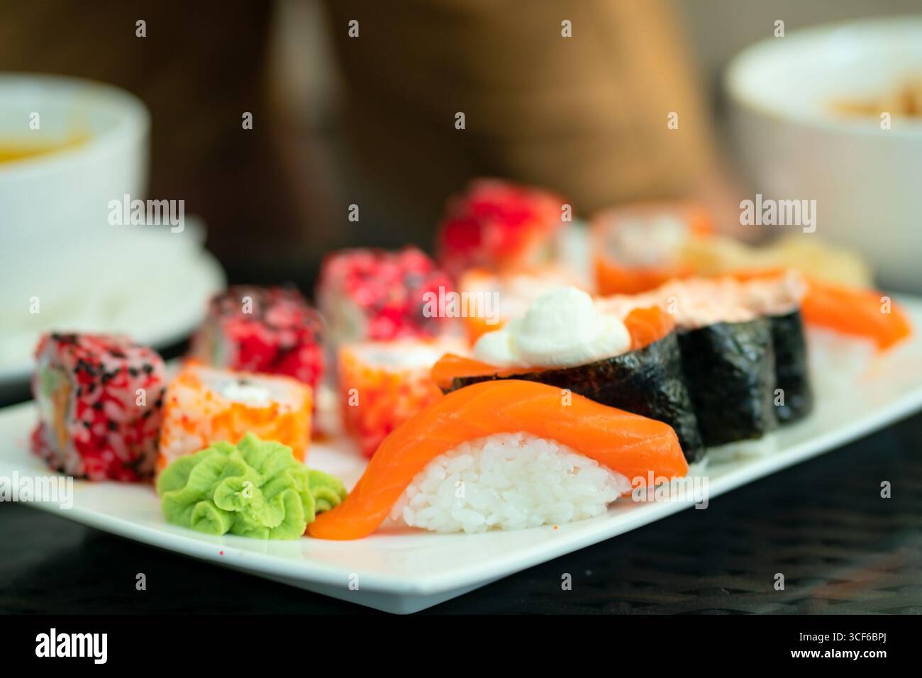 Exquisit angerichtetes japanisches Sushi mit Lachs und Meeresfrüchten. Gesunde Ernährung trifft kulinarische Kunst in diesem proteinreichen Snack. Stockfoto