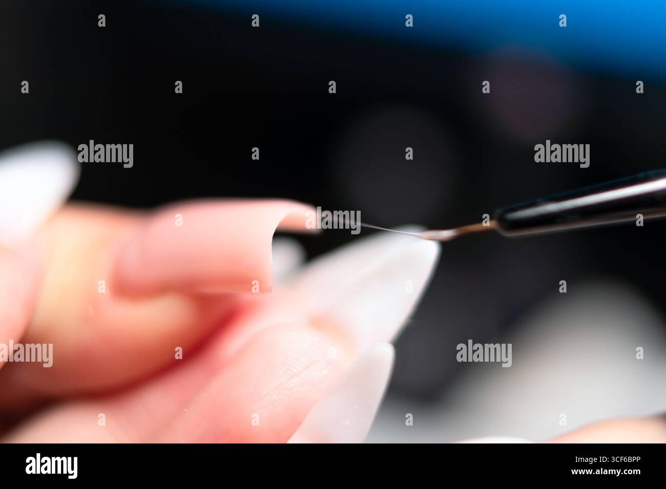 Extreme Nahaufnahme des Manikürs mit winzigem Pinsel, um gellack bei Nagelverlängerung gleichmäßig zu verteilen. Professionelle Schönheit. Stockfoto