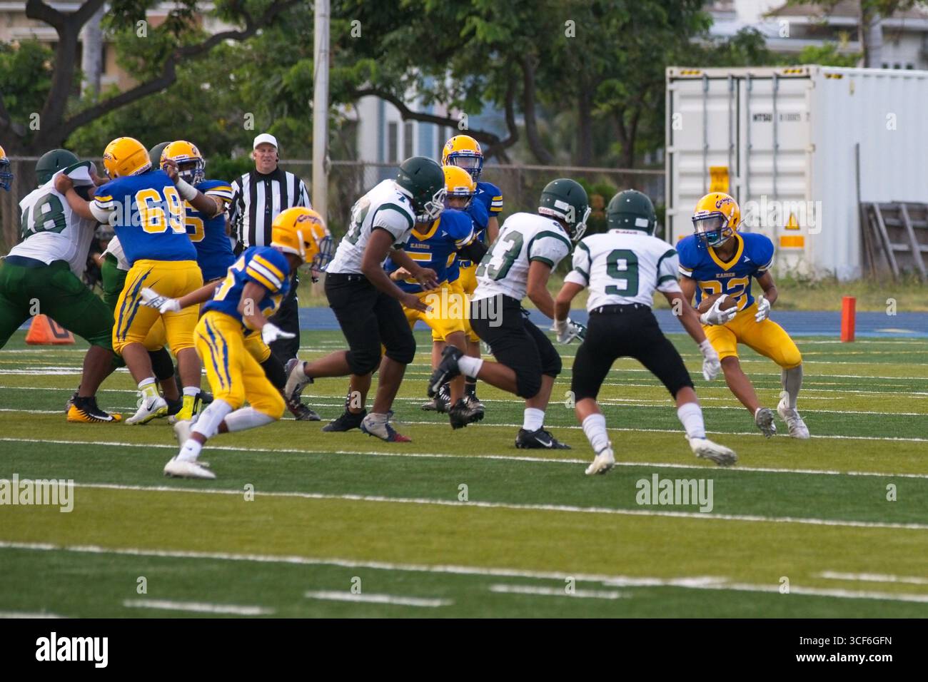 Die High School, die zurück läuft, kämpft um jeden Hof, als ein wilder Verteidiger versucht, ihn auf dem Weg in die Endzone zu stürzen. Stockfoto