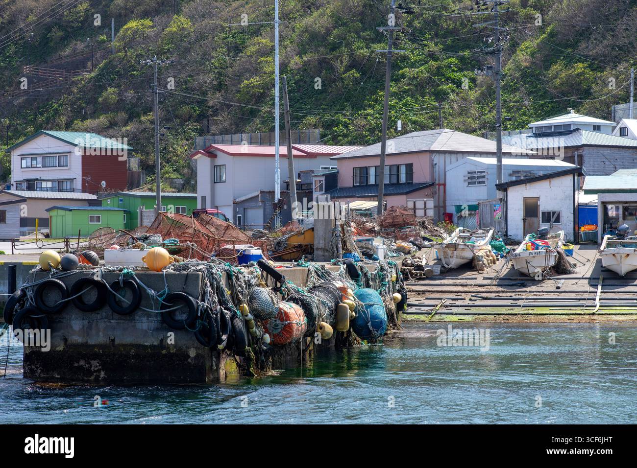 Cape TAPPI, Japan-1. Mai 2025; Fischpier und Fischerboote an der schrägen Pier des TAPPI Fischpiers mit Häusern eines kleinen Fischerdorfes Stockfoto