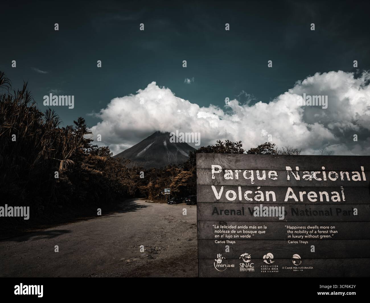 Eintrittsschild für den Vulkan Arenal in Costa Rica mit dem Vulkan im Hintergrund - Smartphone-aufgenommenes Stockfoto
