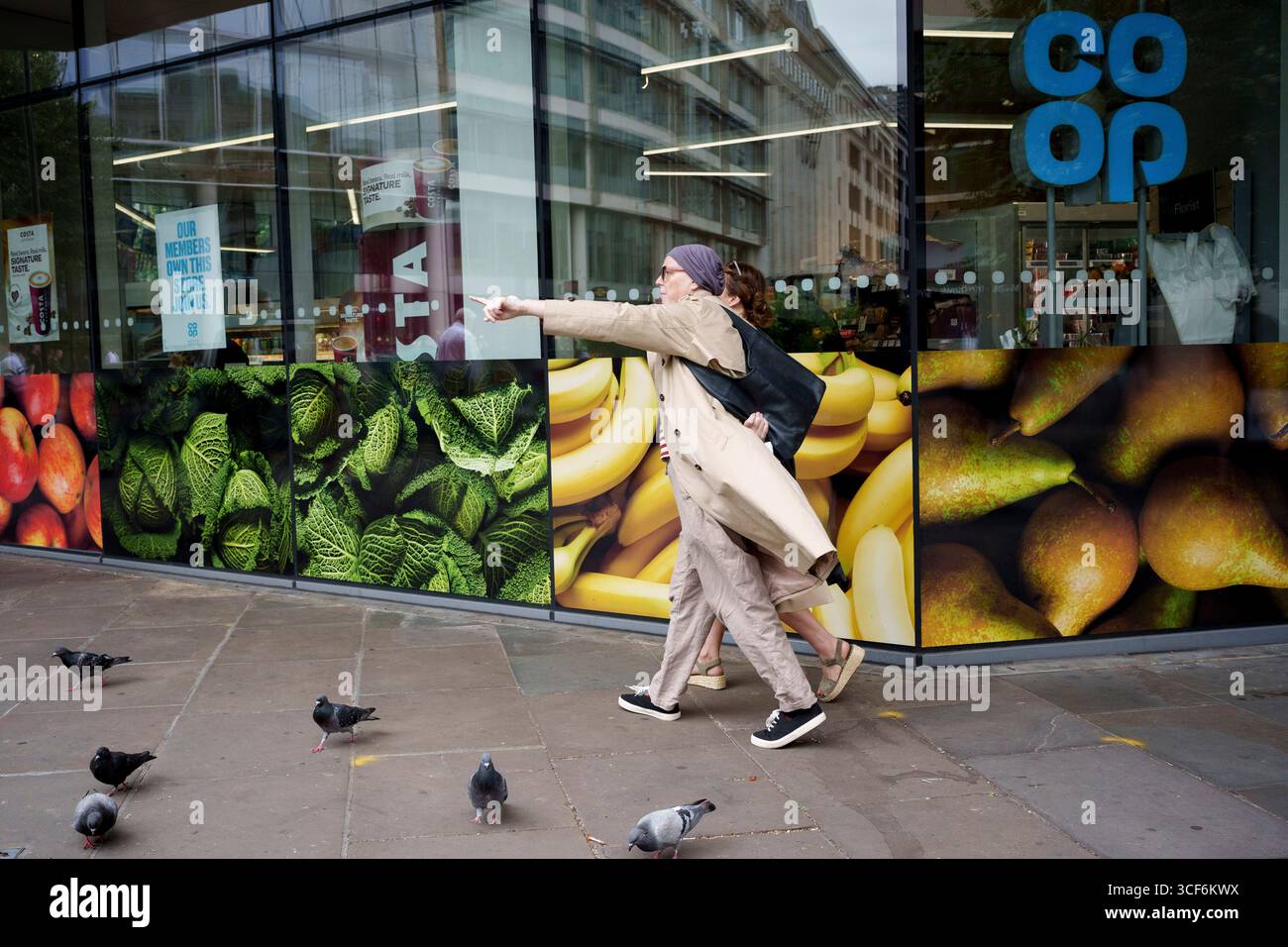 Stadtarbeiter laufen am 20. August 2025 in London, England, an einem Co-OP-Händler in der City of London, dem Finanzviertel der Hauptstadt, vorbei. Stockfoto