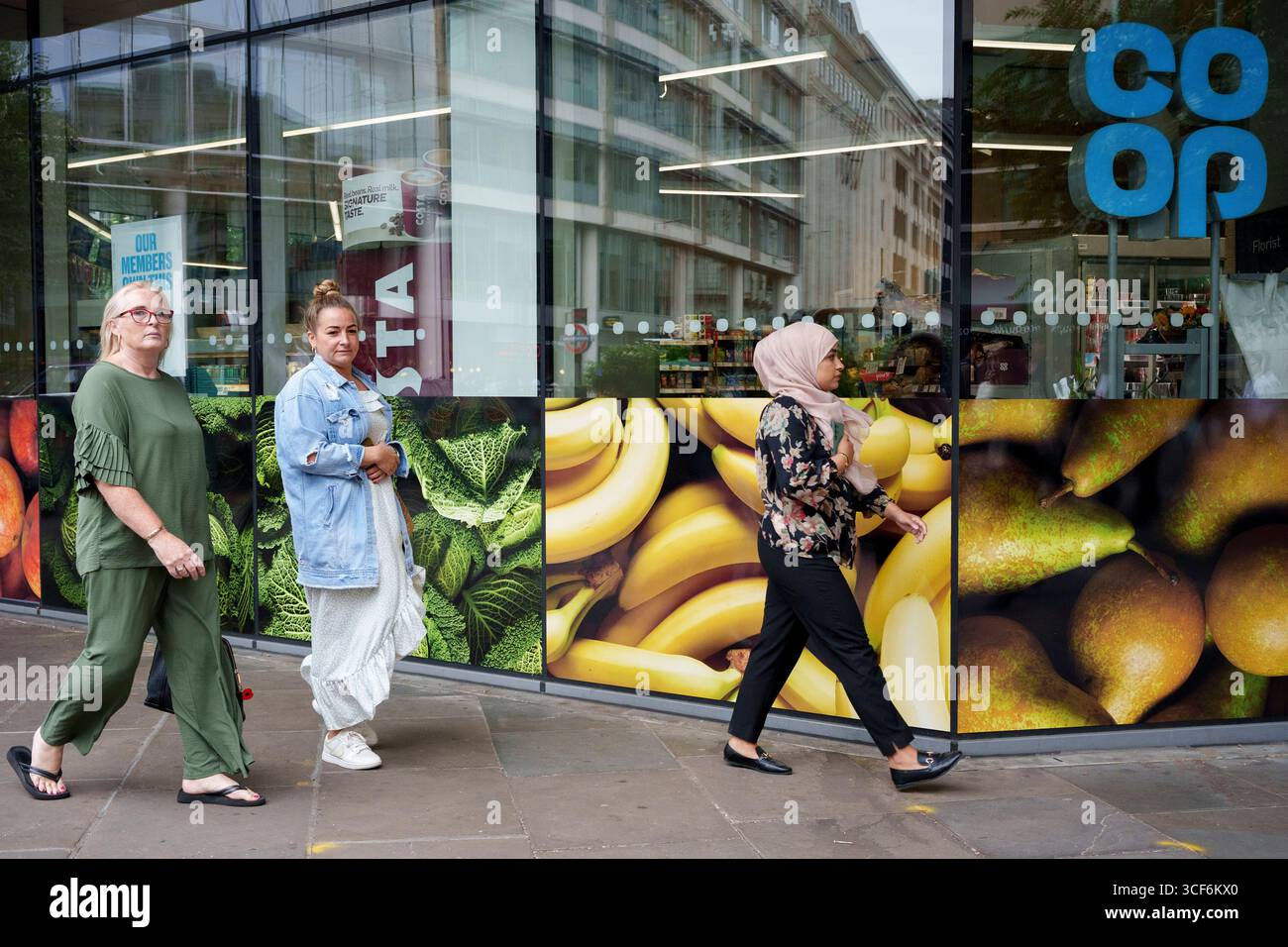 Stadtarbeiter laufen am 20. August 2025 in London, England, an einem Co-OP-Händler in der City of London, dem Finanzviertel der Hauptstadt, vorbei. Stockfoto