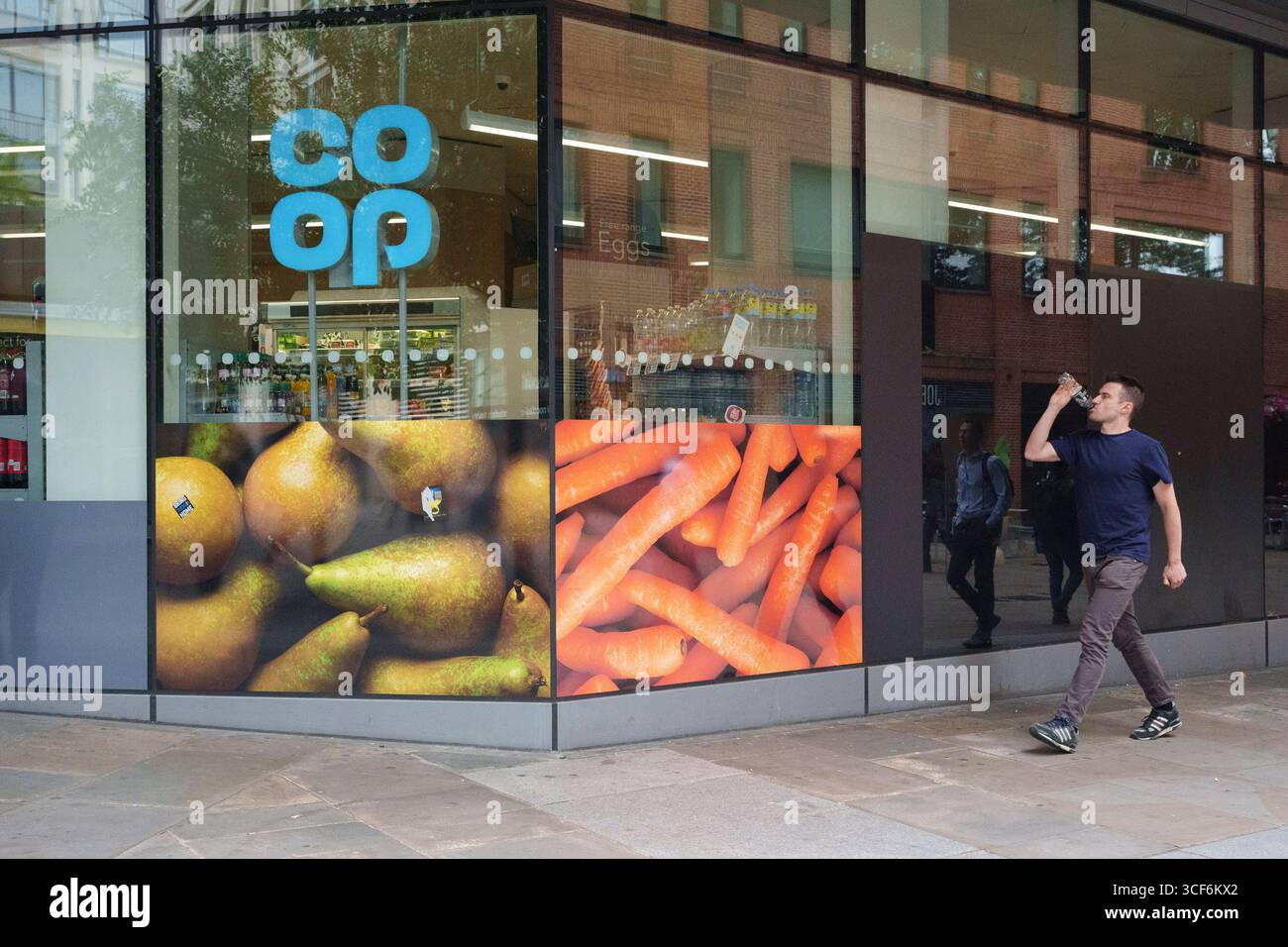 Am 20. August 2025 läuft ein Stadtarbeiter an einem Co-OP-Händler in der City of London, dem Finanzviertel der Hauptstadt, vorbei. Stockfoto