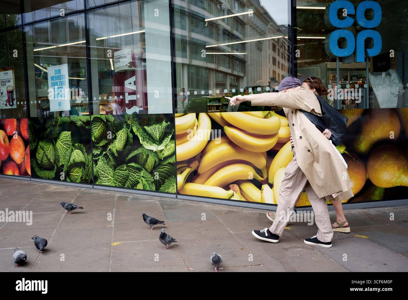 Stadtarbeiter laufen am 20. August 2025 in London, England, an einem Co-OP-Händler in der City of London, dem Finanzviertel der Hauptstadt, vorbei. Stockfoto