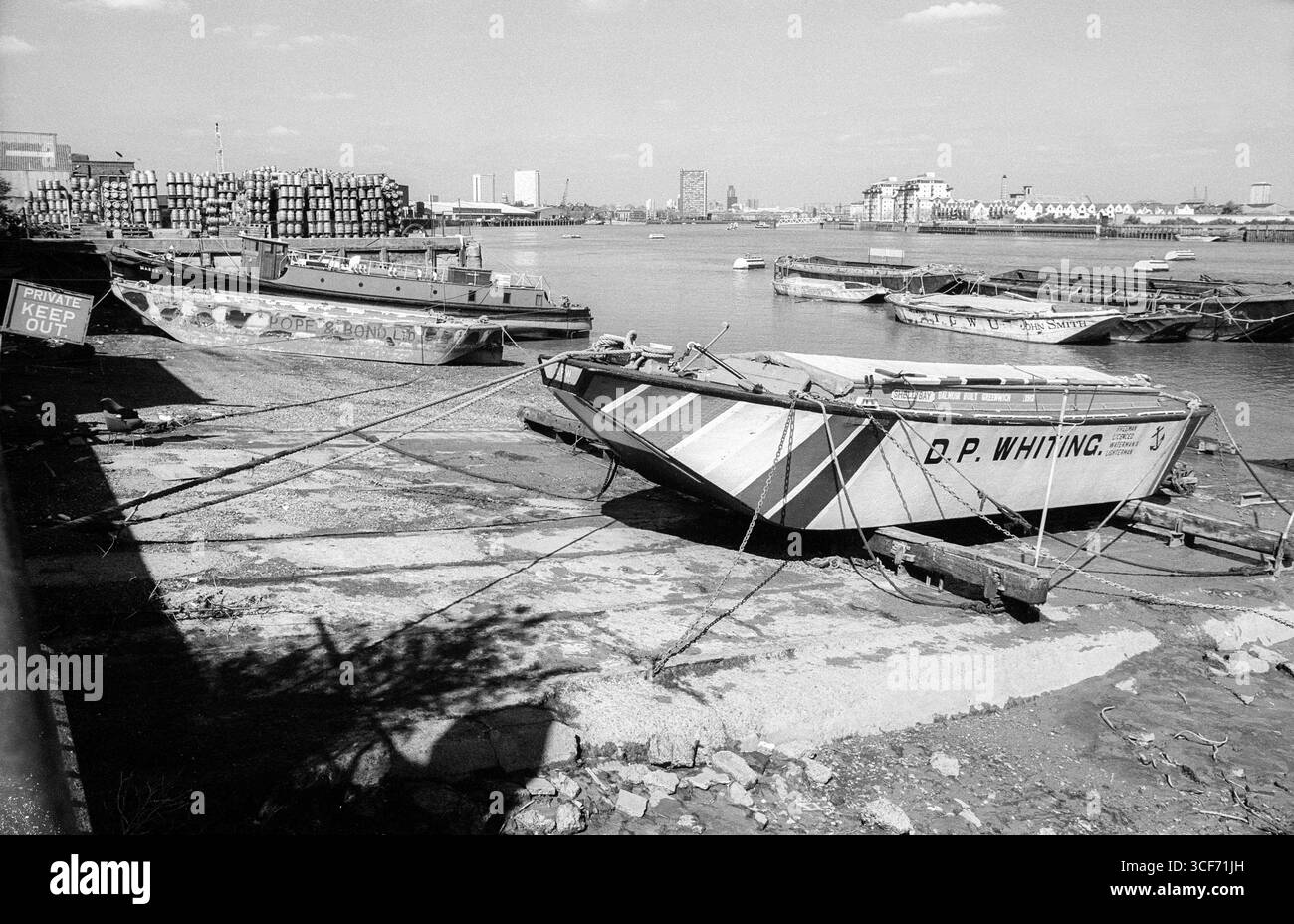 Archivbild der Südseite der Themse aus den 1990er Jahren, westlich von Greenwich aus gesehen. Das Boot in der mittleren Distanz ist die Massey Shaw, vor der Restaurierung. Massey Shaw wurde 1935 auf der Isle of Wight nach einem LCC-Entwurf für den Einsatz als Feuerwehrboot der Londoner Feuerwehr gebaut. Während des Zweiten Weltkriegs unternahm das Boot drei Fahrten im Rahmen der Evakuierung von Dünkirchen und kehrte dann während des Blitz als Feuerwehrboot auf der Themse zurück. Sie wurde 1971 außer Dienst gestellt und erhielt 2008 einen Heritage Lottery Grant zur Restaurierung. Das Boot ist heute als Attraktion im South Dock der West India Docks angelegt. Stockfoto
