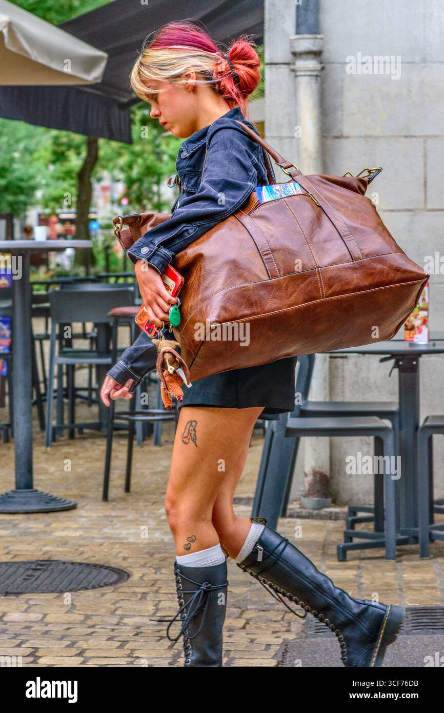 Modische junge Frau (ein Model?) Mit farbigen Haaren, die eine schwere Schultertasche aus Leder tragen, in der Altstadt von Tours, Indre-et-Loire (37), Frankreich. Stockfoto