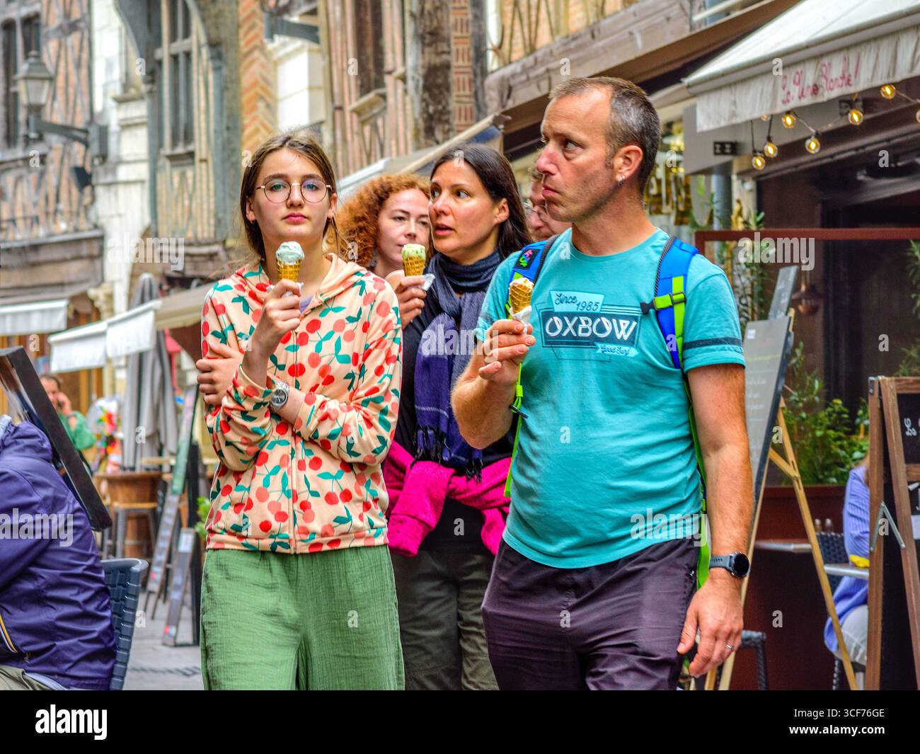 Junge Familie mit Eiscreme, die durch die überfüllte Altstadt von Tours, Indre-et-Loire (37), Frankreich, spaziert. Stockfoto