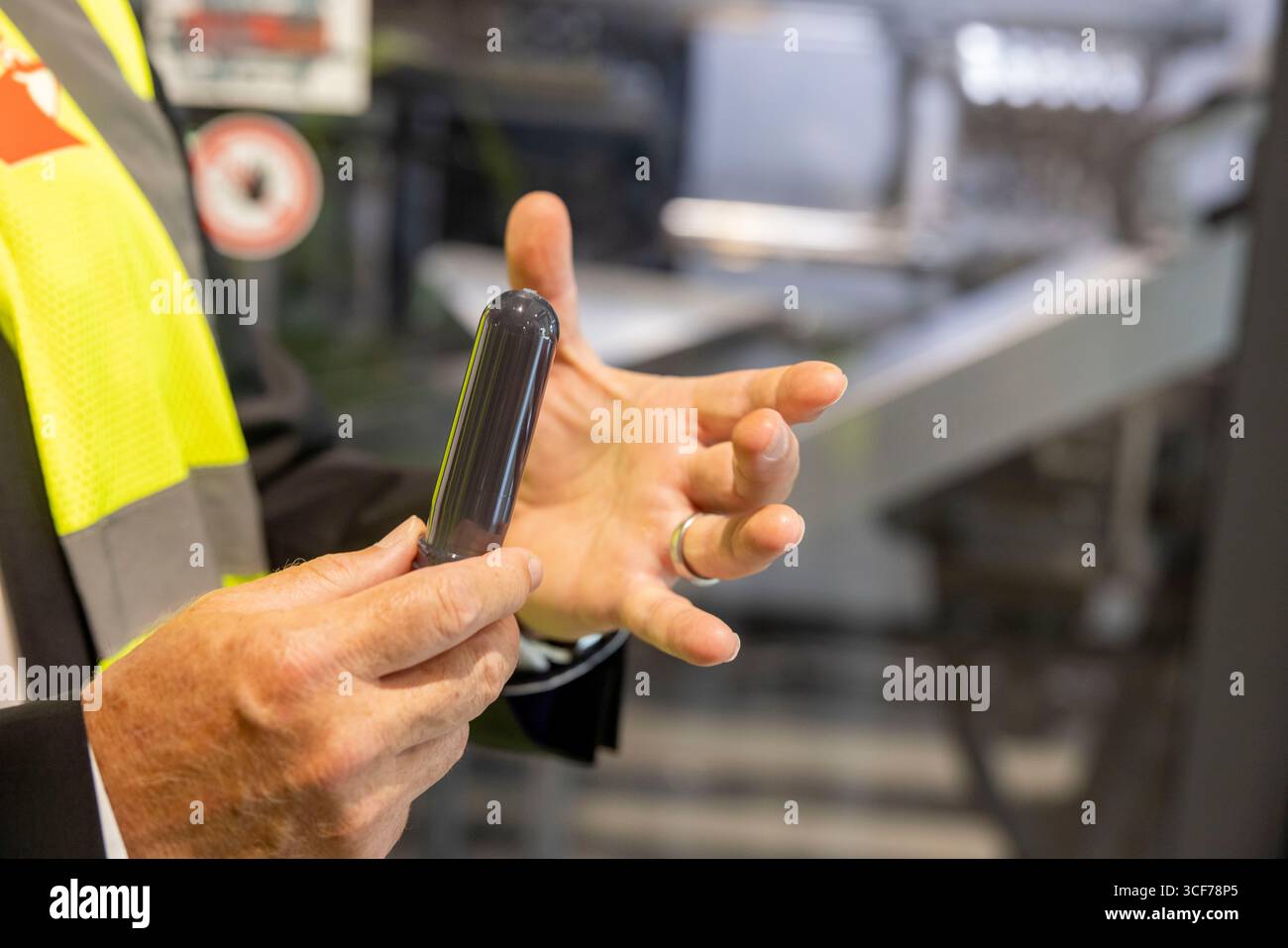 PRODUKTION - 19. August 2025, Rheinland-Pfalz, Mainz: Ein Mitarbeiter hält in einer Produktionshalle der Werner & Mertz GmbH eine Basis für Kunststoffflaschen der Marke Frosch in Händen. In Form und Größe ähnelt es einem Reagenzglas. Doch der kleine Kunststoffschlauch ist vielseitig: Eine Maschine des Verpackungsherstellers Alpla bläst den schmalen Schlauch innerhalb von Sekunden in eine Liter-Flasche. Die Marke Frosch für Reinigungs- und Pflegeprodukte gehört der Mainzer Firma Werner & Mertz GmbH. Das Unternehmen stellt eine breite Palette umweltfreundlicher Produkte her, die in seiner eigenen Unternehmensgruppe hergestellt werden Stockfoto