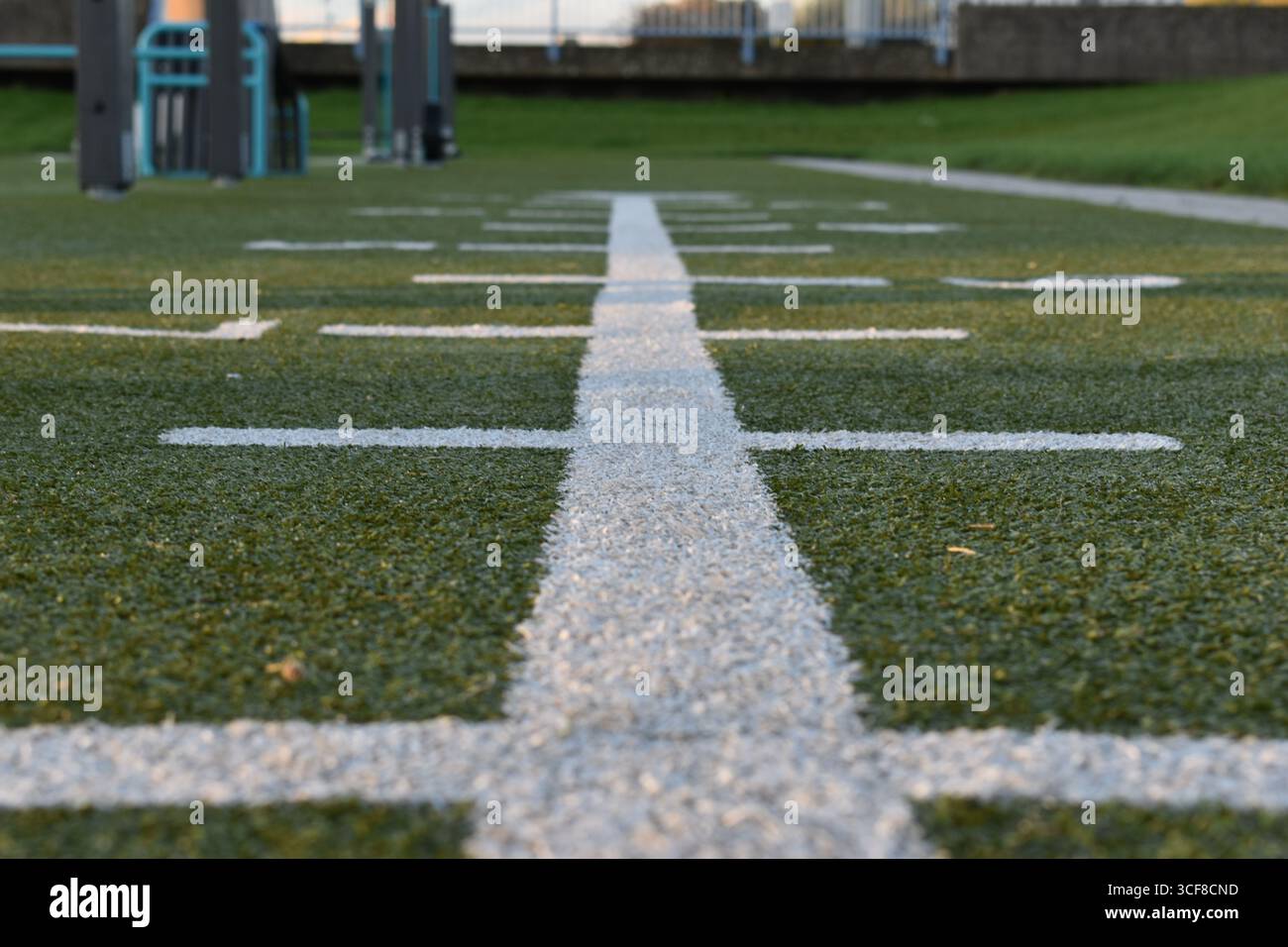 Tiefwinkelansicht der weißen Trainingslinien auf Kunstrasen in einem Outdoor-Fitnesspark Stockfoto