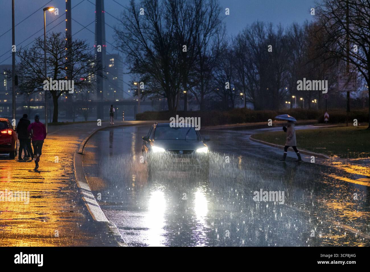 Starkregen verursacht schwierige Straßenverhältnisse in Düsseldorf am Rhein, im Hintergrund die Rheinkniebruecke und der Rheinturm, regnerisches Wetter, Heav Stockfoto