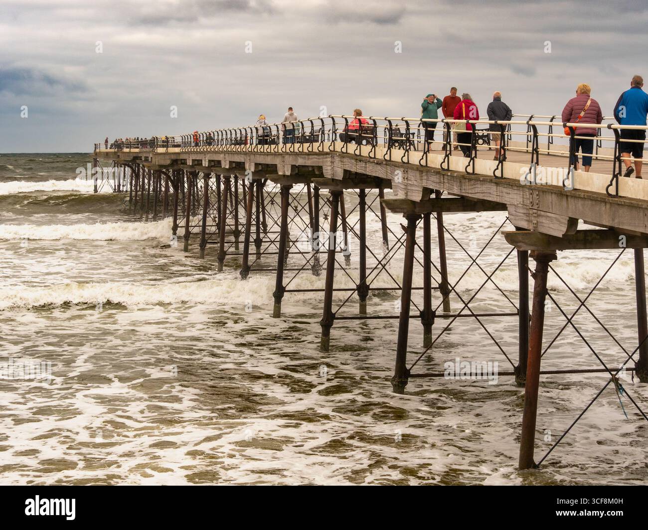 Besucher können das stürmische Meer vom historischen Pleasure Pier in Saltburn-by-the-Sea an der Küste von North Yorkshire, Großbritannien, beobachten. Stockfoto