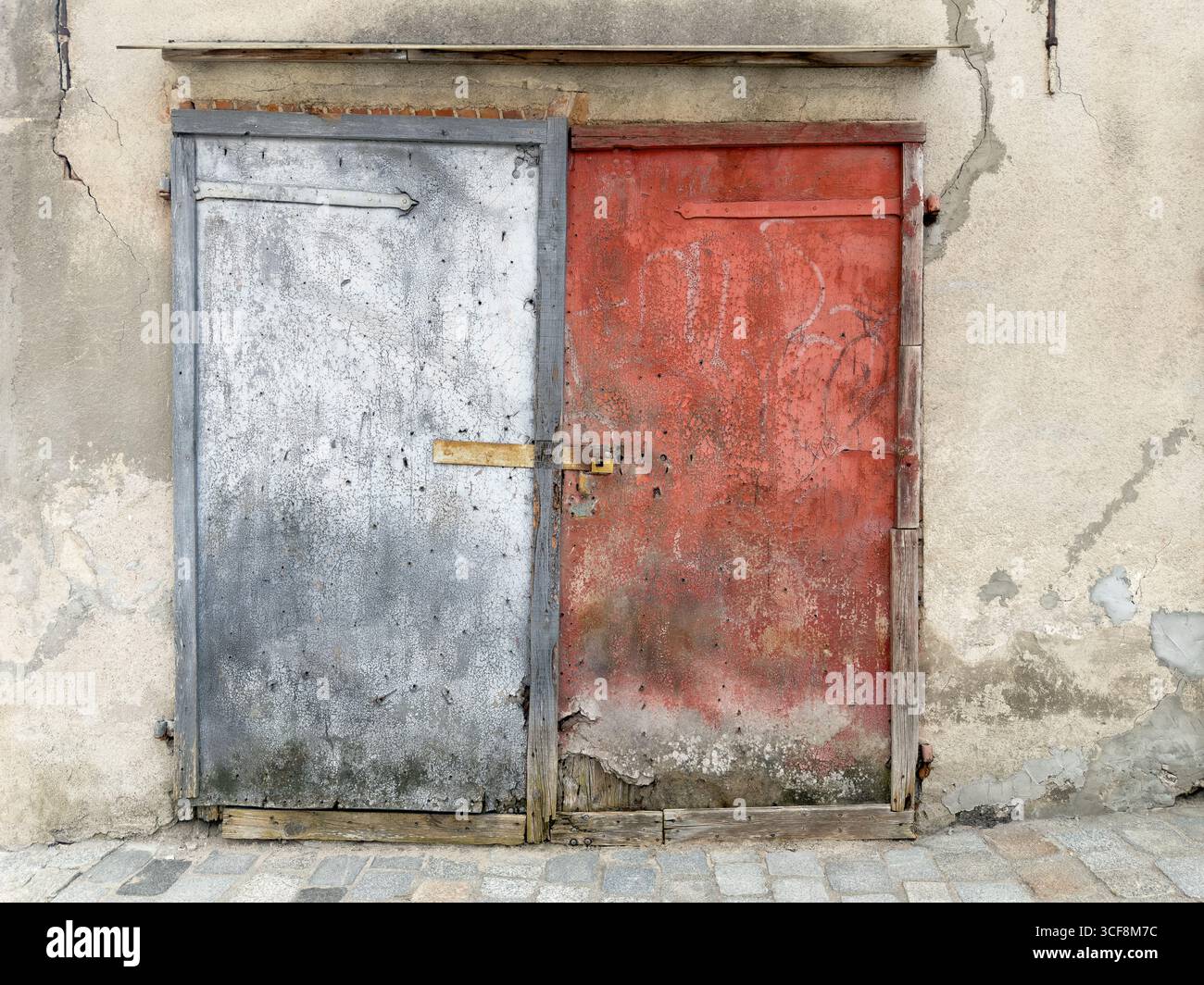 Alte beschädigte Holzeingangstür des Ziegelgebäudes Stockfoto