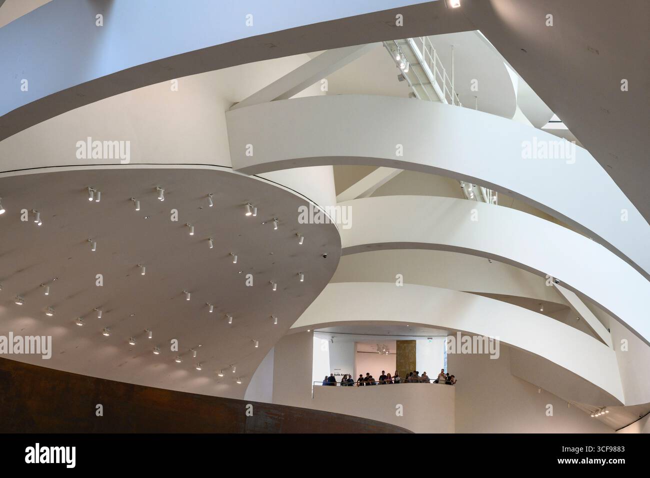 Besucher blicken von einem Innenbalkon im Guggenheim Museum in Bilbao, Nordspanien, Stockfoto