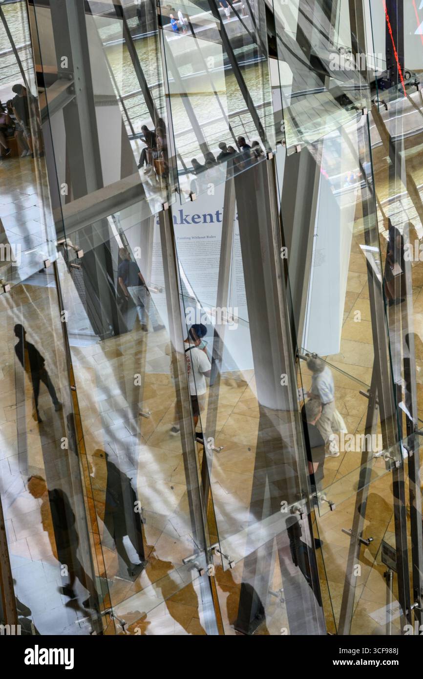 Besucherreflektionen in der Glaswand des Aitriums im Guggenheim Museum in Bilbao, Nordspanien, Stockfoto