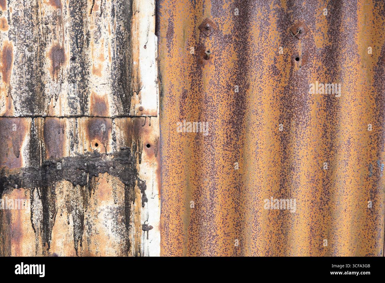 Nahaufnahme von rostigen Metallblechen mit kontrastierenden Flecken und Mustern, Texturen und Farben, die an Alter, Verfall und Charaktereigenschaften erinnern Stockfoto