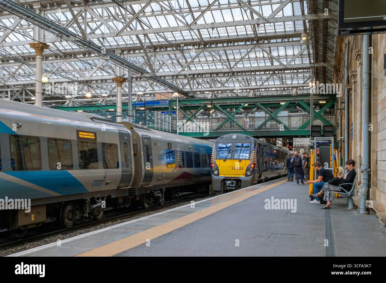 Bahnsteig 10 am Bahnhof Waverley, Edinburgh, mit einem TransPennine Express-Zug neben einer British Rail Class 334, 334025. Stockfoto