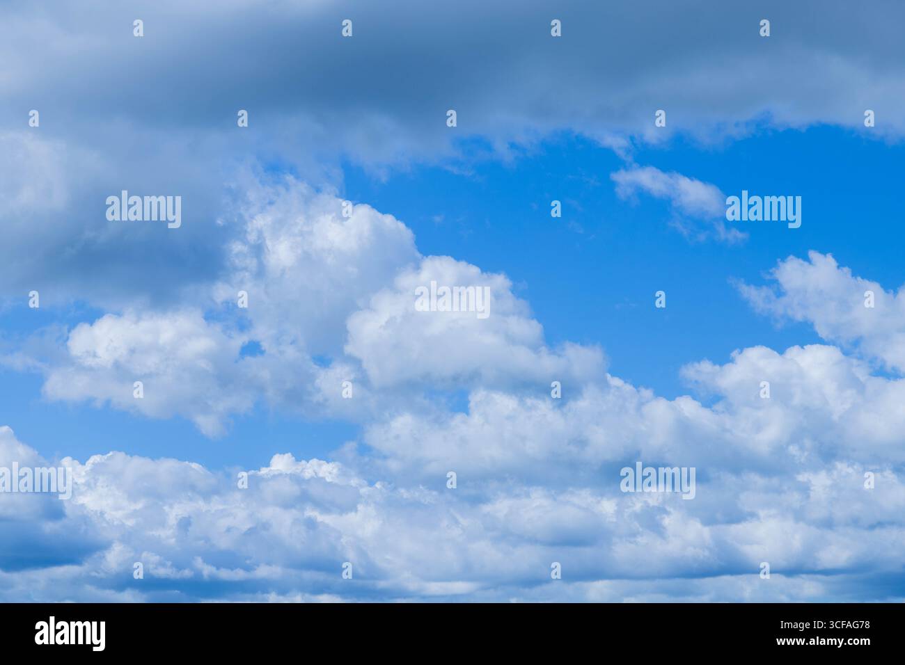 Die Sonne scheint durch die geschwollenen Wolken. Blick auf den Himmel. Wunderschöner, sonniger Himmel. Hintergrund mit Wolken auf blauem Himmel. Wolken auf blauem Himmel. Stockfoto
