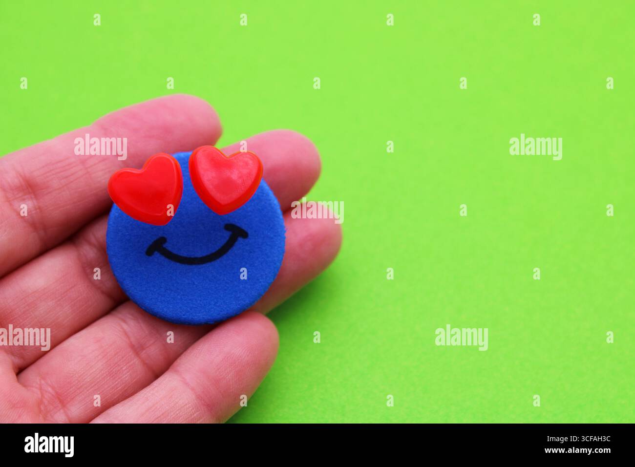 Die Hand hält ein glückliches Gesicht mit liebevollen Augen Stockfoto