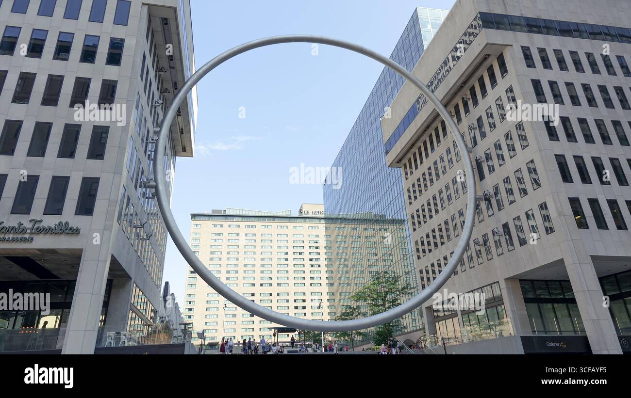 Montreal QC, Kanada - 20. Juli 2025: Die Ringskulptur am Place Ville Marie in Montreal ist von modernen Gebäuden umgeben, die einen lebendigen Eindruck vermitteln Stockfoto