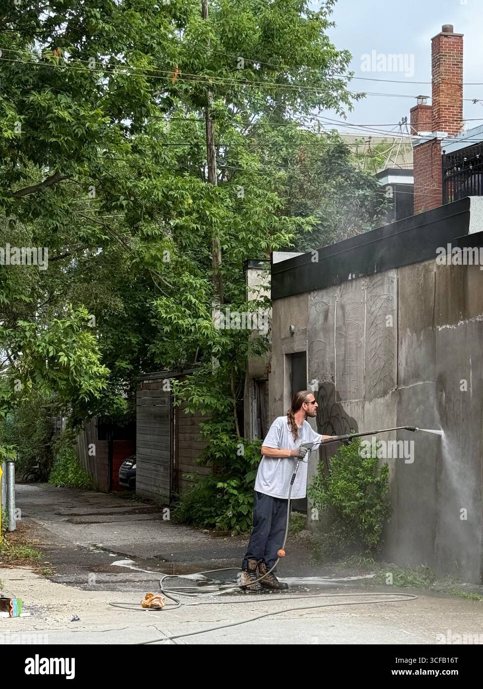 Mann, der Graffiti von der Wand entfernt, Montreal Kanada Stockfoto