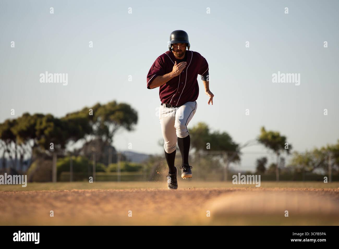 Staub tritt aus dem Schotterweg unter dem Baseballschuh auf dem Infield nahe dem Außenzaun auf Stockfoto