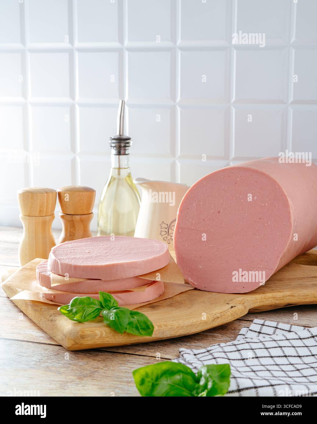 Gekochte Wurst auf einem Holzbrett mit Kräutern Stockfoto