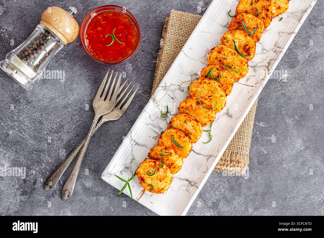 Gebratene Kartoffelscheiben mit Würzmitteln Stockfoto
