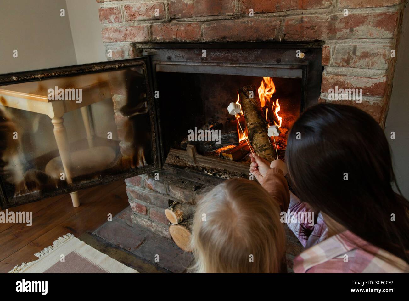 Wärme am Kamin mit der Familie in einem rustikalen Wohnzimmer Stockfoto