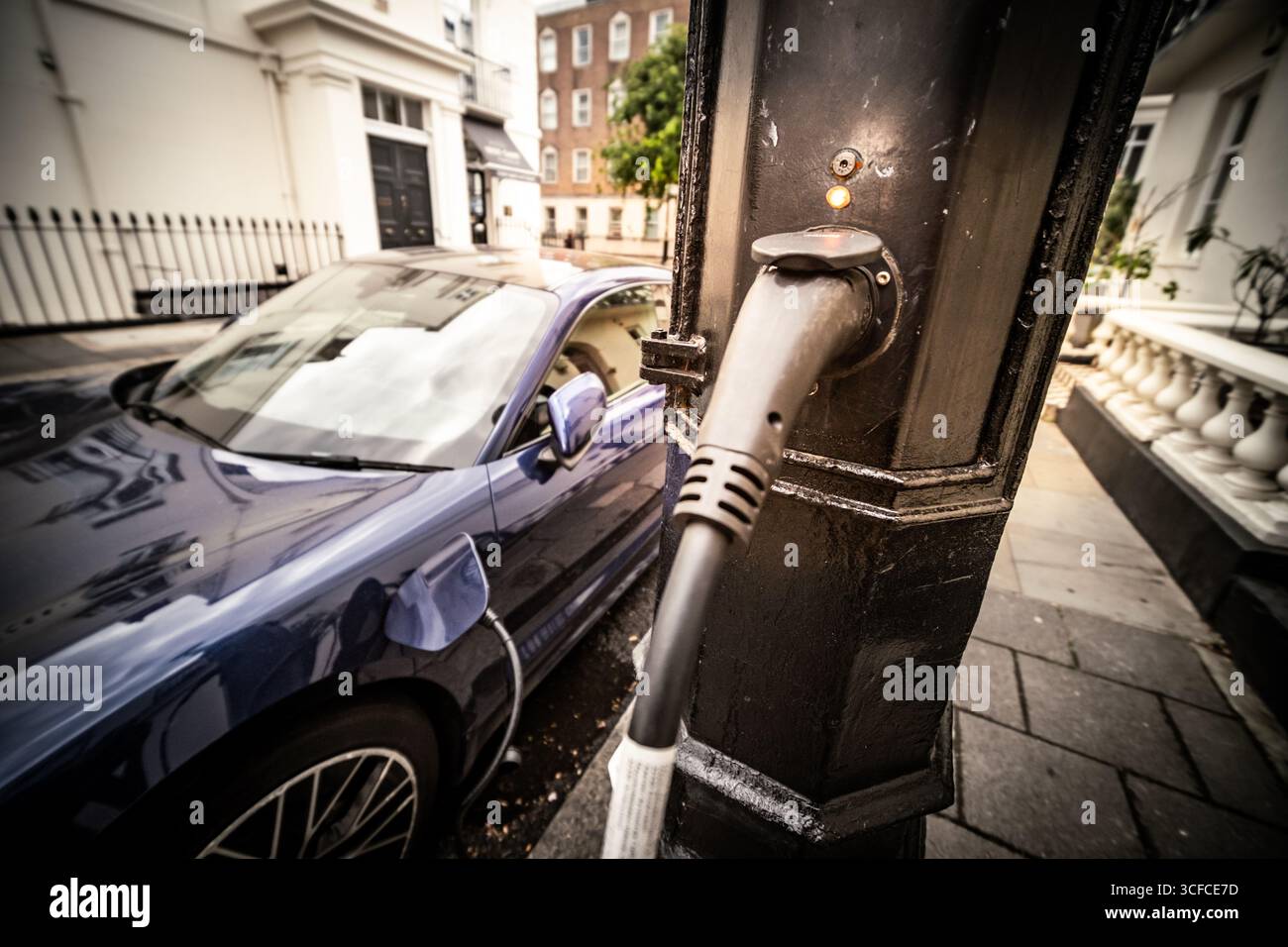 Elektroauto, das über eine Lampen-Ladestation in städtischen Städten Großbritanniens aufgeladen wird Stockfoto