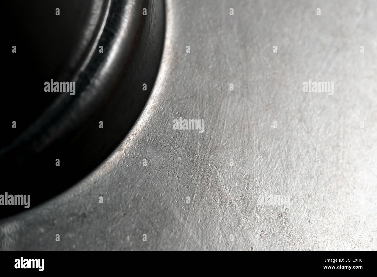 Nahaufnahme einer Metalloberfläche mit einzigartigen Mustern und leichtem Zusammenspiel. Stockfoto